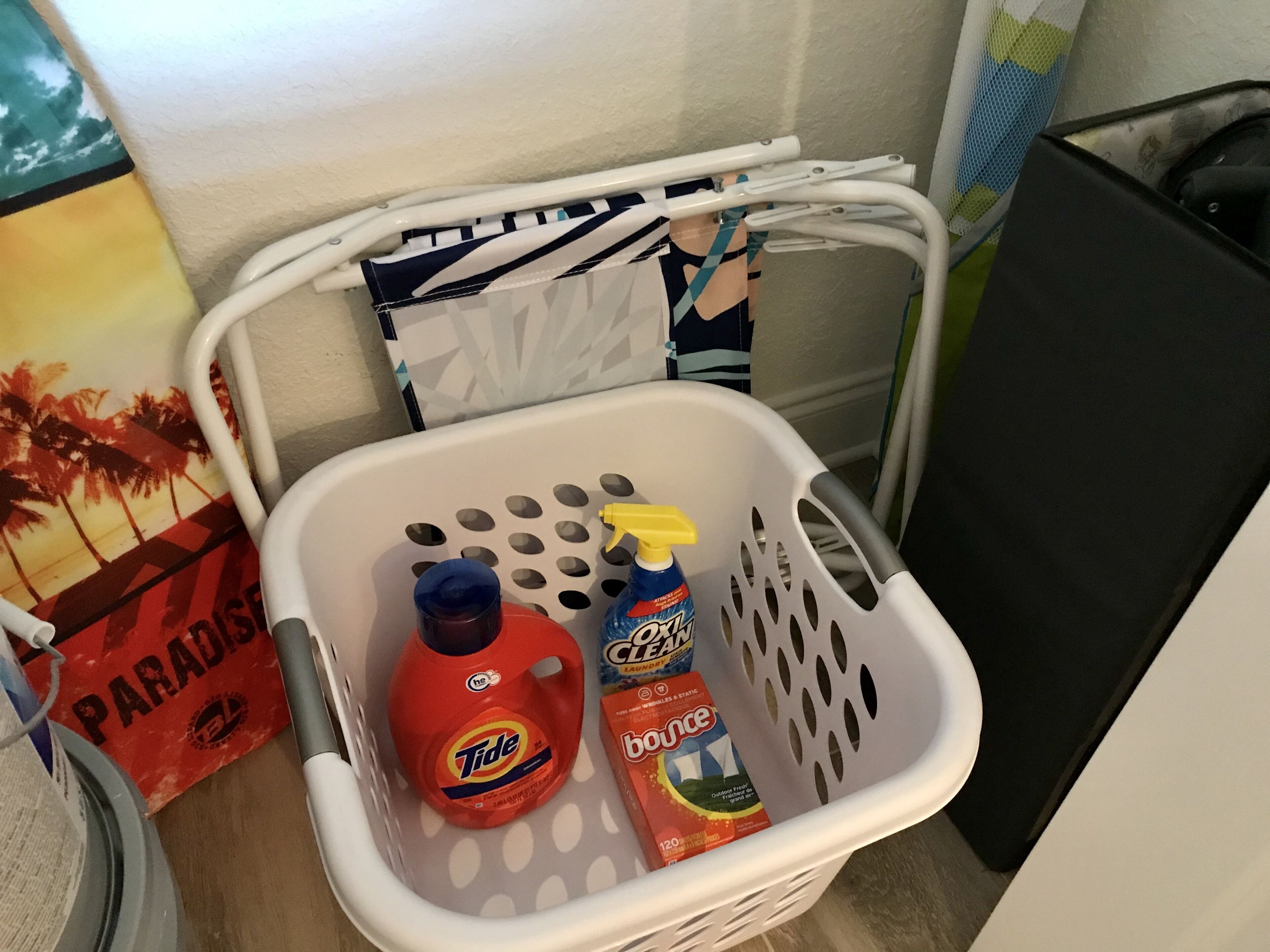 A laundry basket containing Tide detergent and Bounce fabric softener.