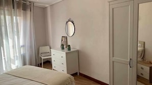A bedroom with a bed, a dresser, a mirror, and a wardrobe. - Arostegi Etxea - unique apartment next to the port (Bermeo)