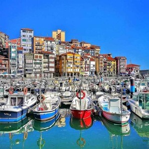 Uma marina com barcos atracados em frente a edifícios coloridos.