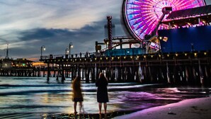 A pier with a large illuminated Ferris wheel and a beach in the background. - Santa Monica Beach Luxury Suite (Santa Monica)