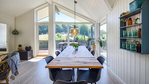 A spacious dining area with a long wooden table, black chairs, and a hanging light fixture. - Beautiful home in Ebeltoft with kitchen (Ebeltoft)