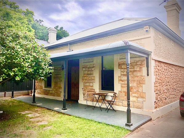 Enjoy outdoor dining or relaxation on the covered patio with a table and chairs.