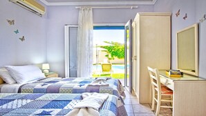 Quarto com cama, escrivaninha e vista para uma piscina e vegetação.