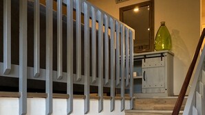 A wooden staircase with a metal railing and a green bottle on top. - Beautiful Bi-level. Game room with pool table, 5 UHDTVs, WiFi. Central heat/air. (Bushkill)