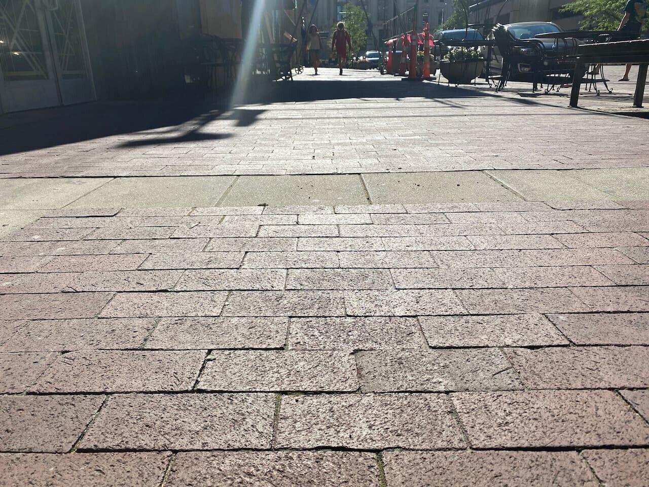 Ein gepflasterter Weg mit einem Gittermuster aus rechteckigen Fliesen.