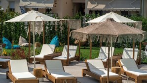 A poolside area with lounge chairs and umbrellas. - Mirablue Luxury Residences (Kassandra)