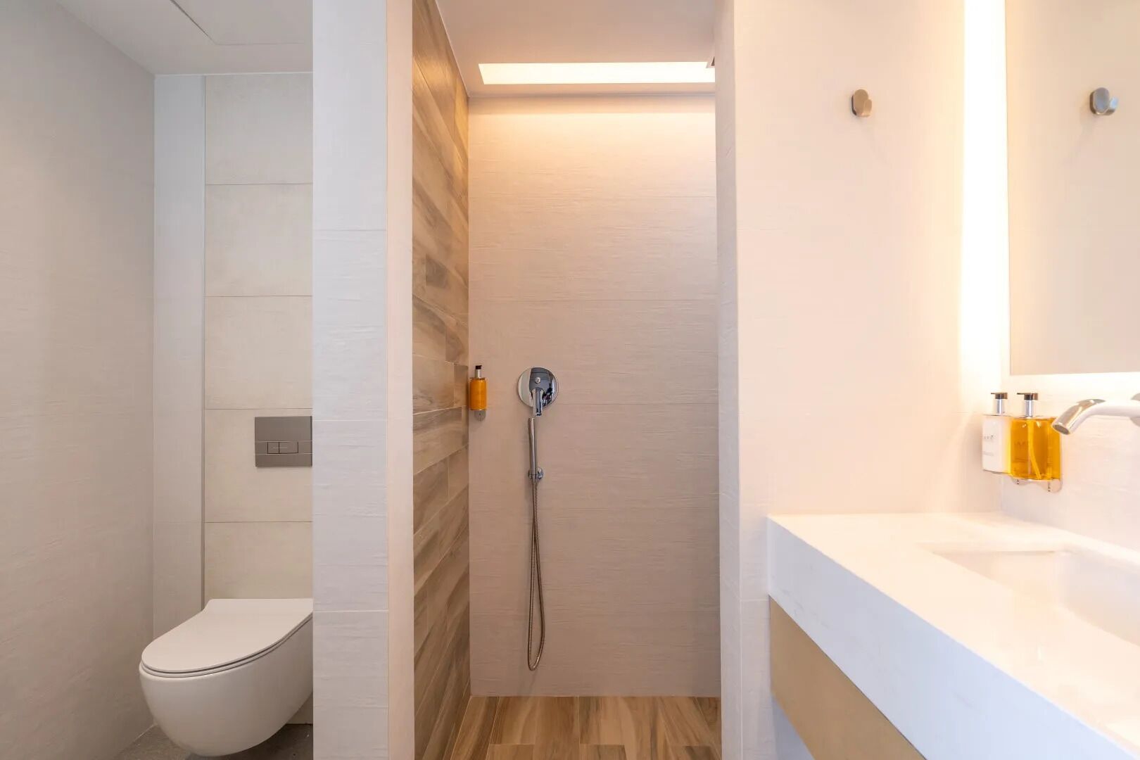 Une salle de bain moderne équipée de toilettes, d’une douche et d’un lavabo.