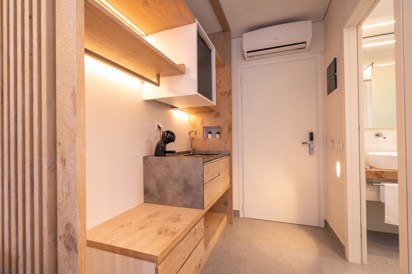 A modern bathroom with a wooden vanity, a shower, and a toilet.