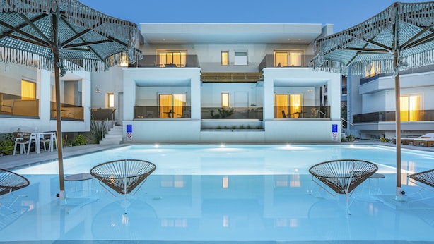 A modern hotel with a central pool, outdoor seating, and a two-story structure. - Mirablue Luxury Residences (Kassandra)