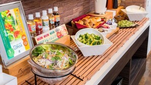A buffet setup with various food items and condiments.