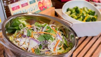 A salad bowl with mixed greens and shredded carrots on a wooden table.