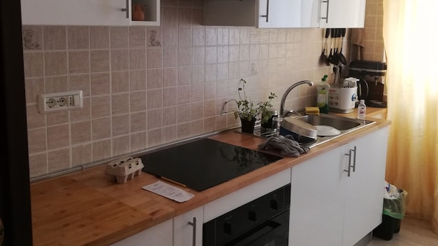 A modern kitchen with white cabinets, a black countertop, and a built-in oven. - The house with an Italian chef inside (Bologna)