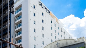 Ett förstklassigt hotell med en modern fasad, flera balkonger och en klar himmel.