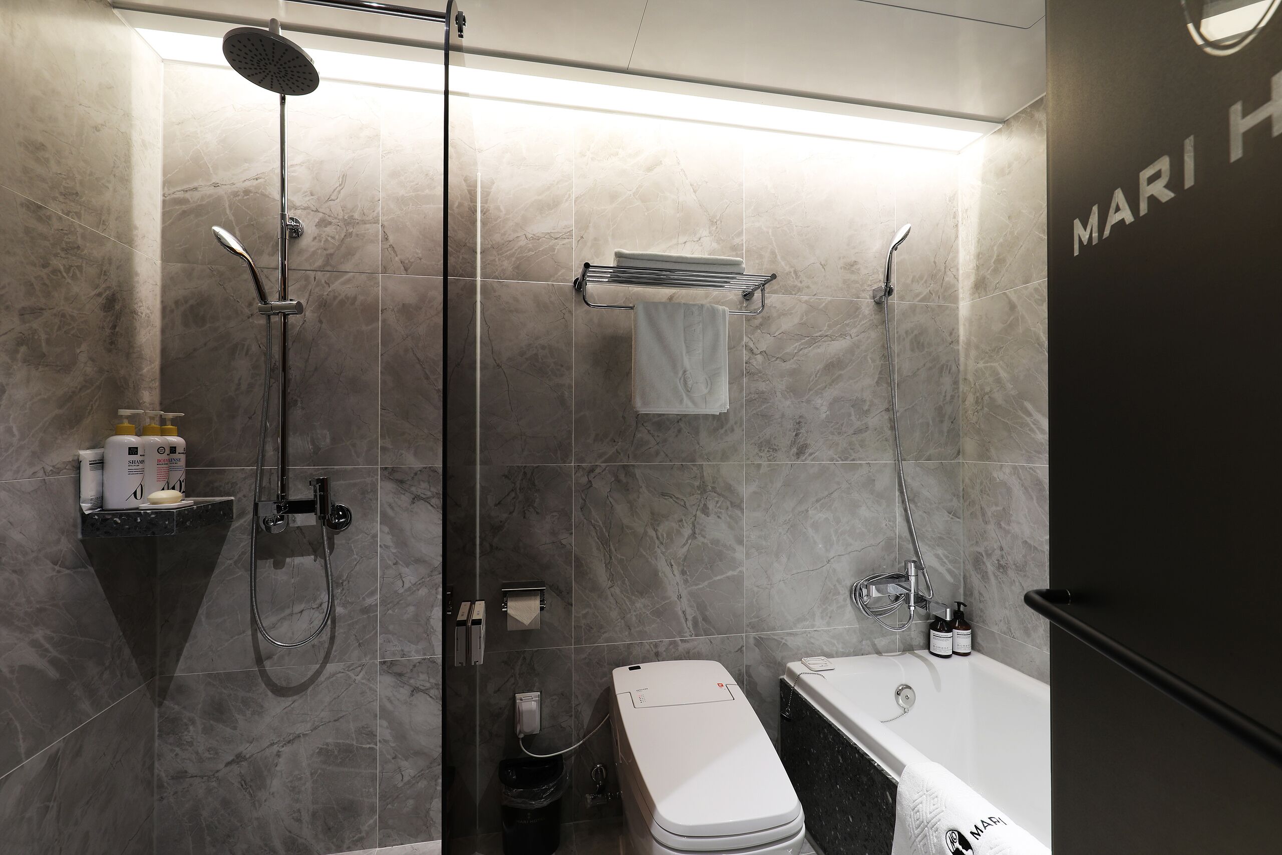 A modern bathroom with a shower, toilet, and bathtub.