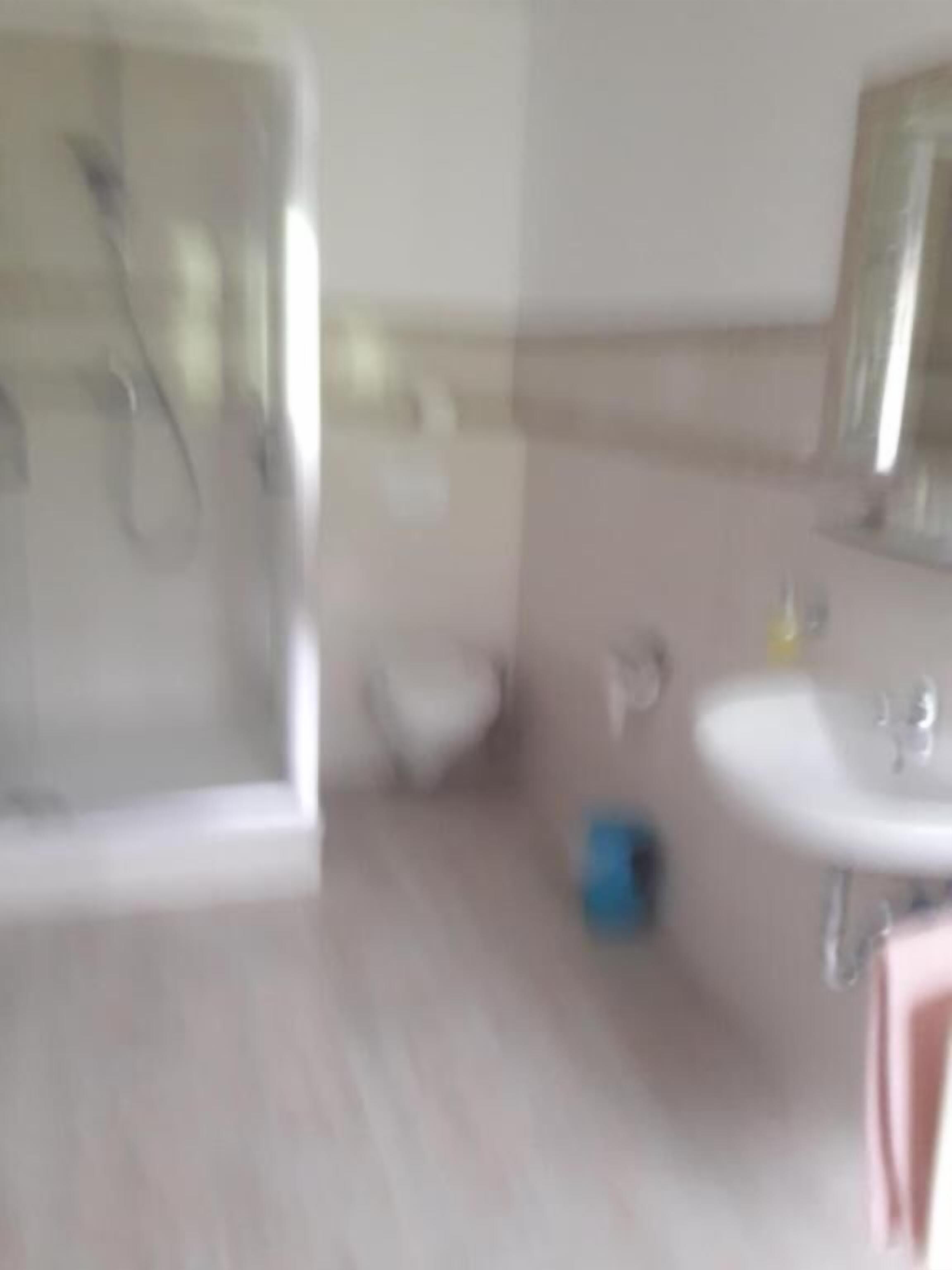 Un bagno con doccia, lavandino e specchio.