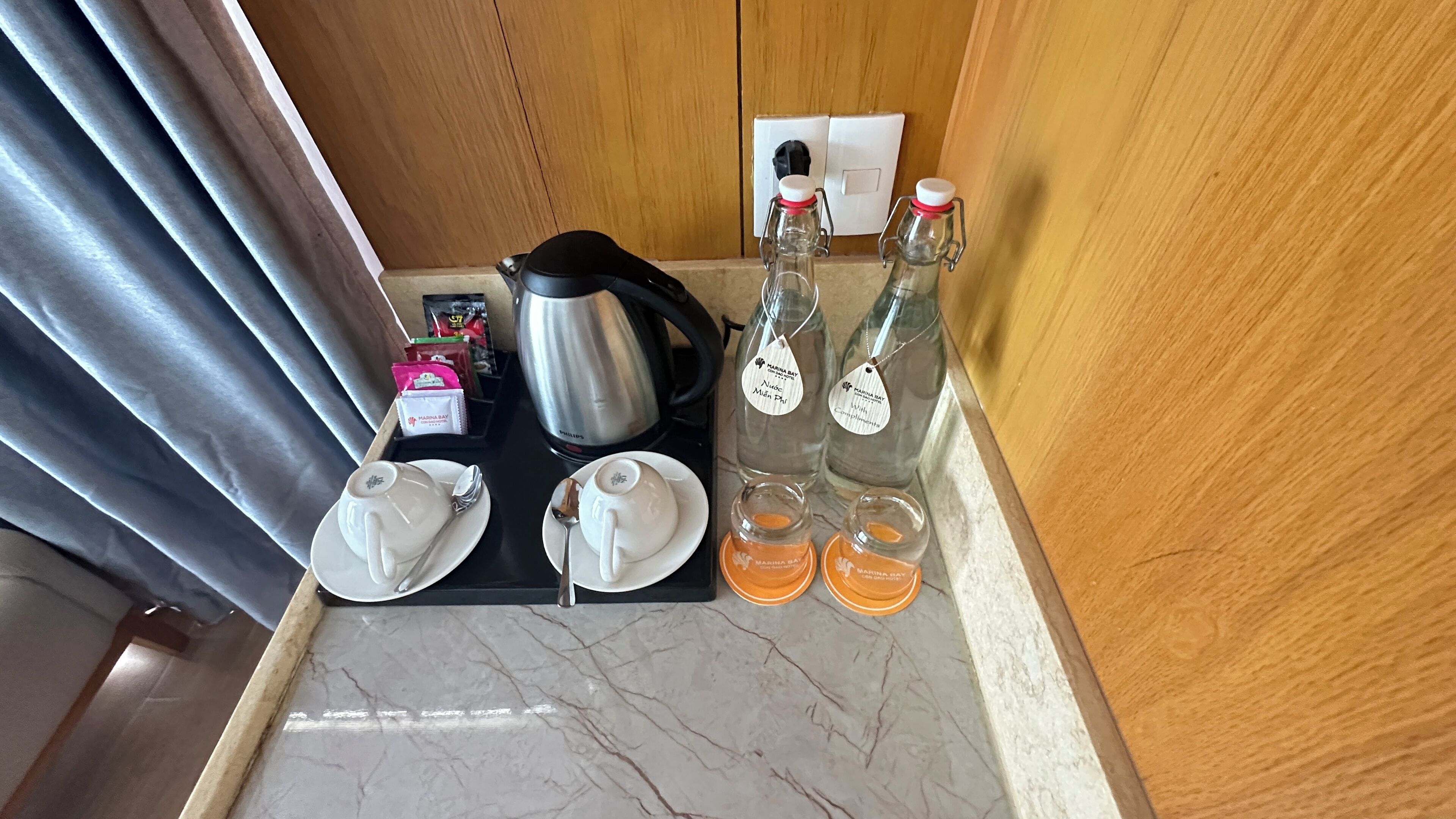 Et minibar-arrangement med kaffemaskine, tepakke og vandflasker.