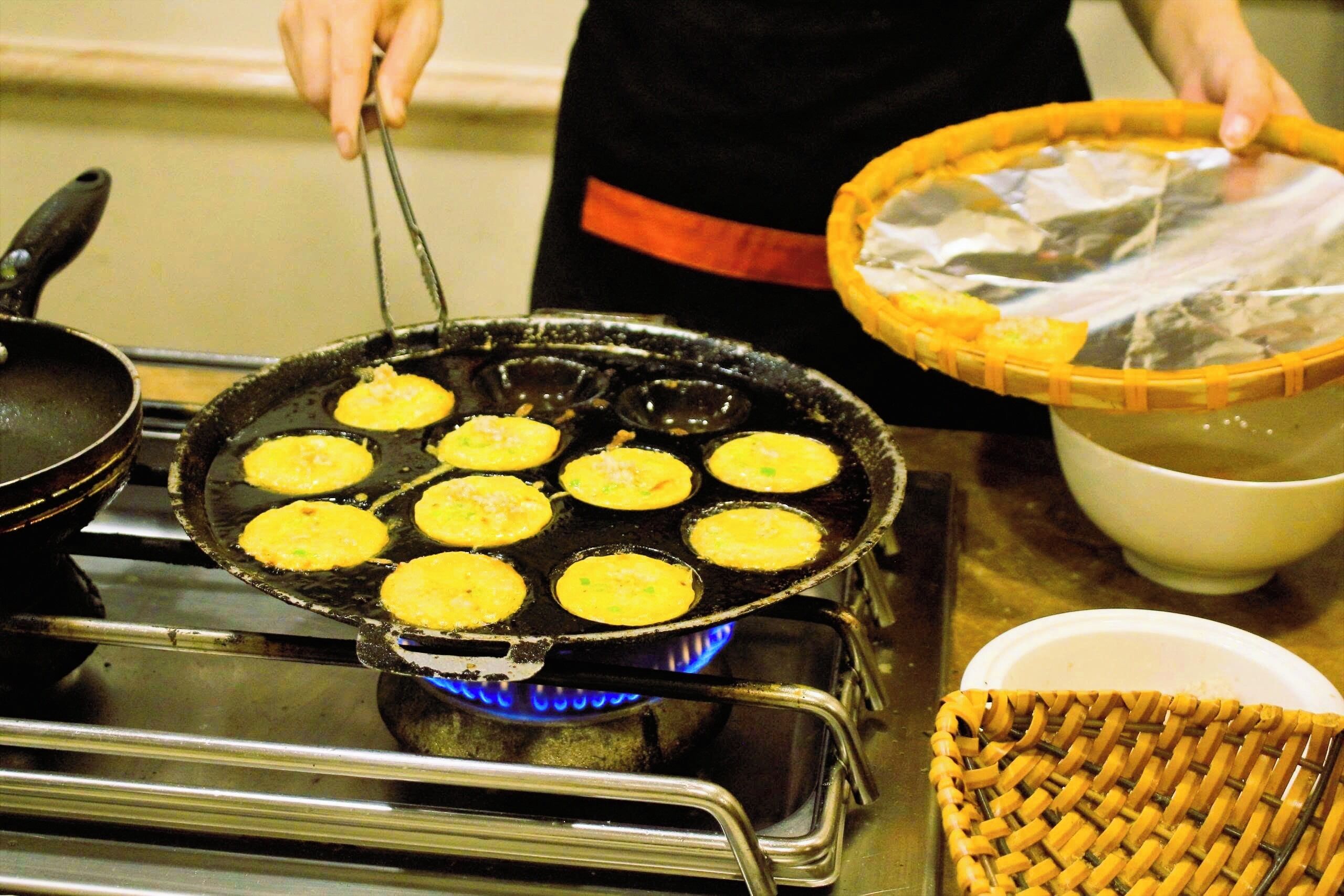 A cooking pan with food items on a stove.