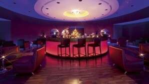 A bar area with a circular seating arrangement, a central bar counter, and a chandelier. - Millenium Hotel Ramallah (Ramallah)