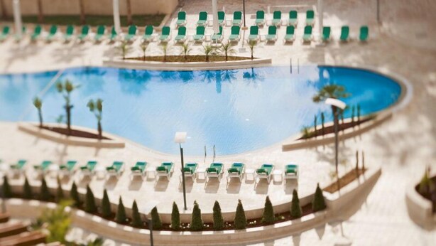 A model of a pool area with lounge chairs and a boat. - Millenium Hotel Ramallah (Ramallah)