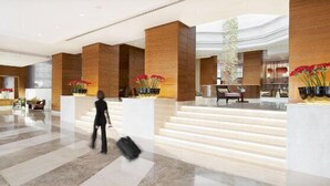 A spacious lobby with marble flooring, wooden columns, and a central staircase. - Millenium Hotel Ramallah (Ramallah)