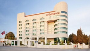 A modern hotel with a curved facade, multiple windows, and a prominent entrance. - Millenium Hotel Ramallah (Ramallah)