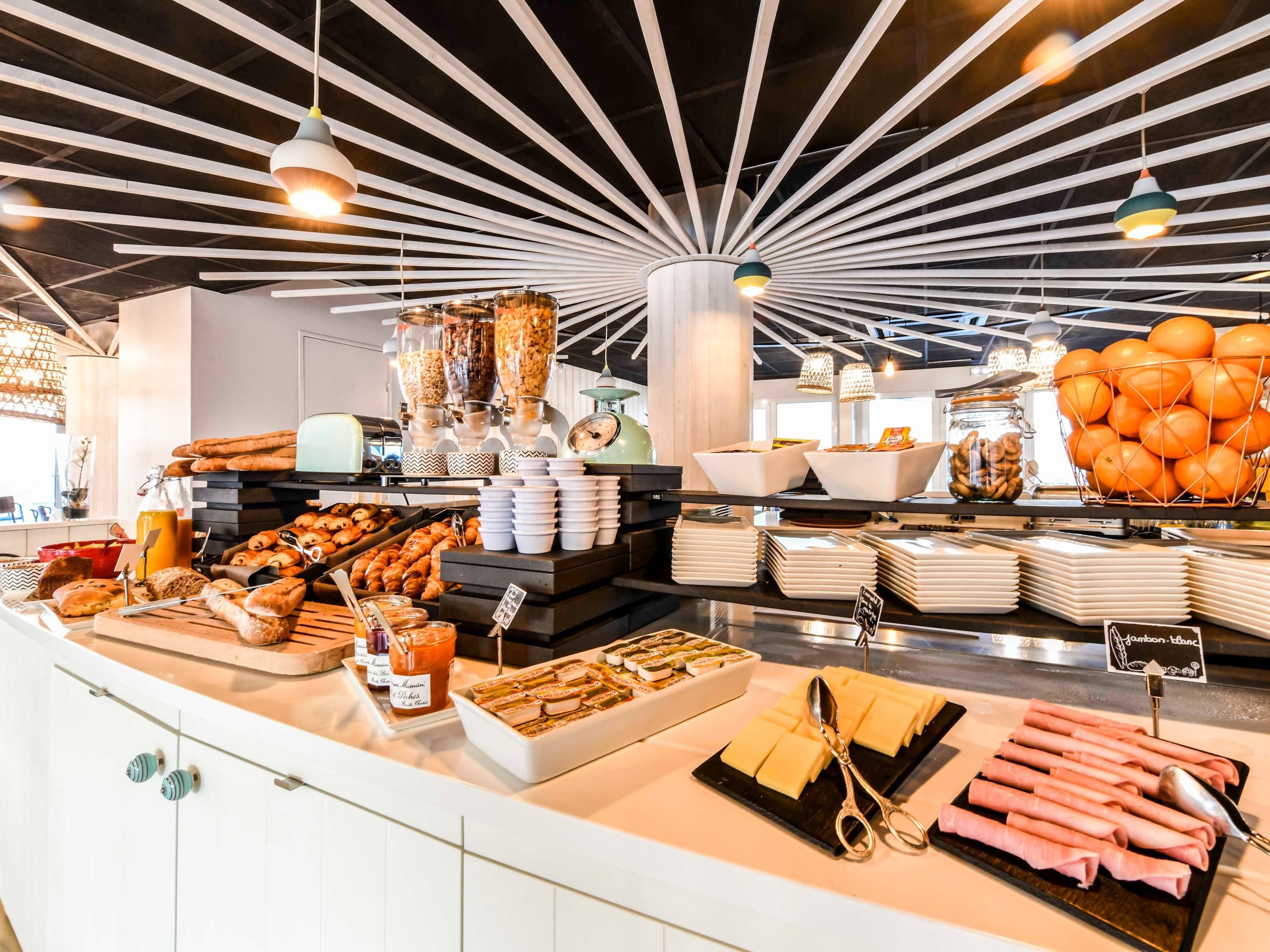 Un buffet amb diversos aliments, com ara pastissos, fruites i condiments.