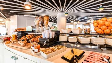 Un buffet amb diversos aliments, com ara pastissos, fruites i condiments.