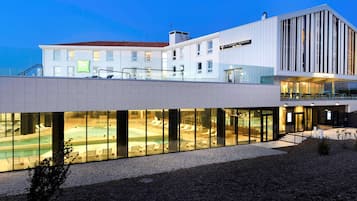 Un hotel modern amb zona de piscina, terrassa i restaurant.