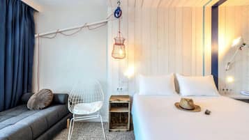 Habitació d'hotel moderna amb un llit, una cadira, un penjallum i un panell de capçal de fusta.