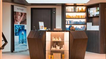 A reception desk with a glass display case, a digital screen, and a Phytomer advertisement.