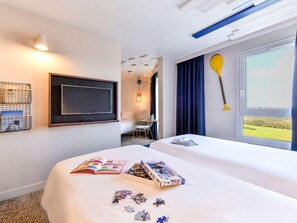 A hotel room with a bed, a desk with a chair, a TV, and a window with a view. - Ibis Styles La Rochelle Thalasso Chatelaillon (Chatelaillon-Plage)