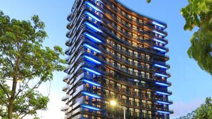 A modern high-rise building with multiple balconies and a curved facade. - Huafa Exhibition Executive Aparthotel (Zhuhai)