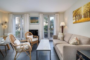 Relax in this inviting living space with a comfortable sofa, armchair, and flat-screen TV.