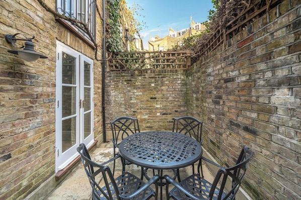 Enjoy a tranquil retreat in this charming courtyard with a round table and four chairs.