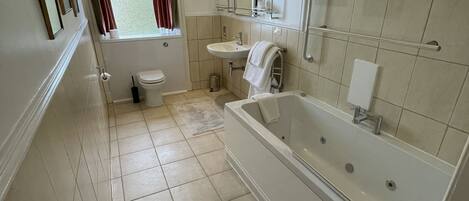 A bathroom with a bathtub, sink, and toilet.