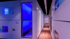 A hallway with a wooden floor, numbered room 36, and a blue-lit door. - An Hotel Jakarta (Jakarta)