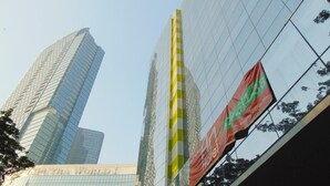A modern hotel with a glass facade and a prominent 'Hotel' sign. - An Hotel Jakarta (Jakarta)