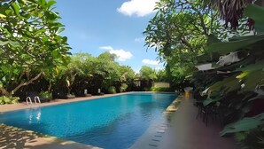 Una piscina circondata da lussureggiante vegetazione e alberi.