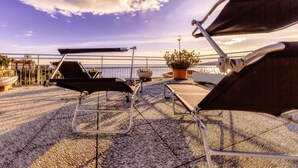 A rooftop terrace with two lounge chairs, a potted plant, and a street lamp. - CASAVIVA - PRIMAVERA 1a RAPALLO (Zoagli)