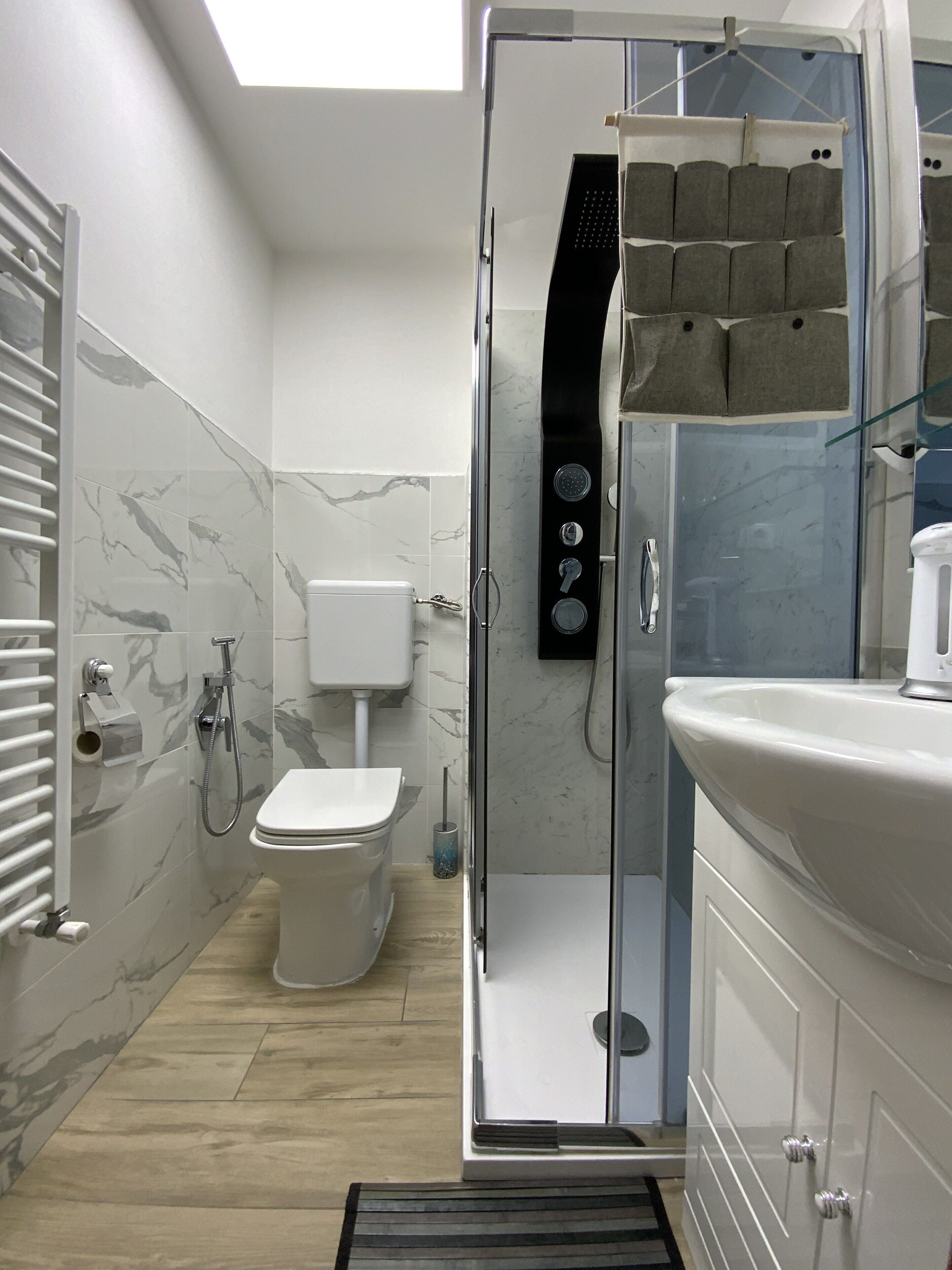 A modern bathroom with a glass-enclosed shower, a toilet, and a sink.