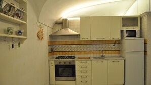 Eine kompakte Küche mit Herd, Backofen, Mikrowelle und Kühlschrank.