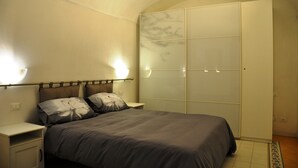 Ein Schlafzimmer mit einem Bett, Nachttischen und einem Kleiderschrank.