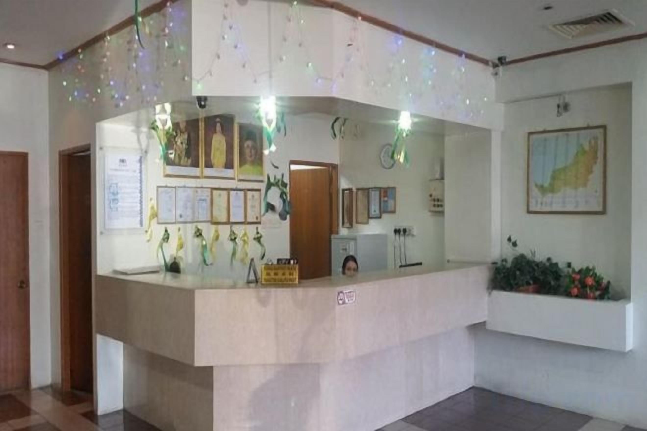 A reception desk with a counter, framed certificates, and a small plant on the wall.