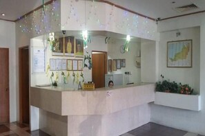 A reception desk with a counter, framed certificates, and a small plant on the wall. - Hotel Meligai Kapit (Kapit)