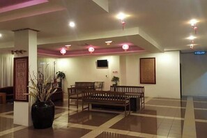 A lobby with a checkered floor, seating area, and a large vase with plants. - Hotel Meligai Kapit (Kapit)