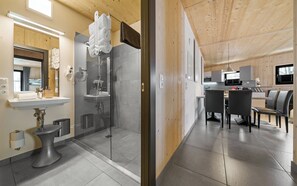 A modern bathroom with a glass shower, a sink, and a toilet. - Aparthotel Zell am See (Zell am See)