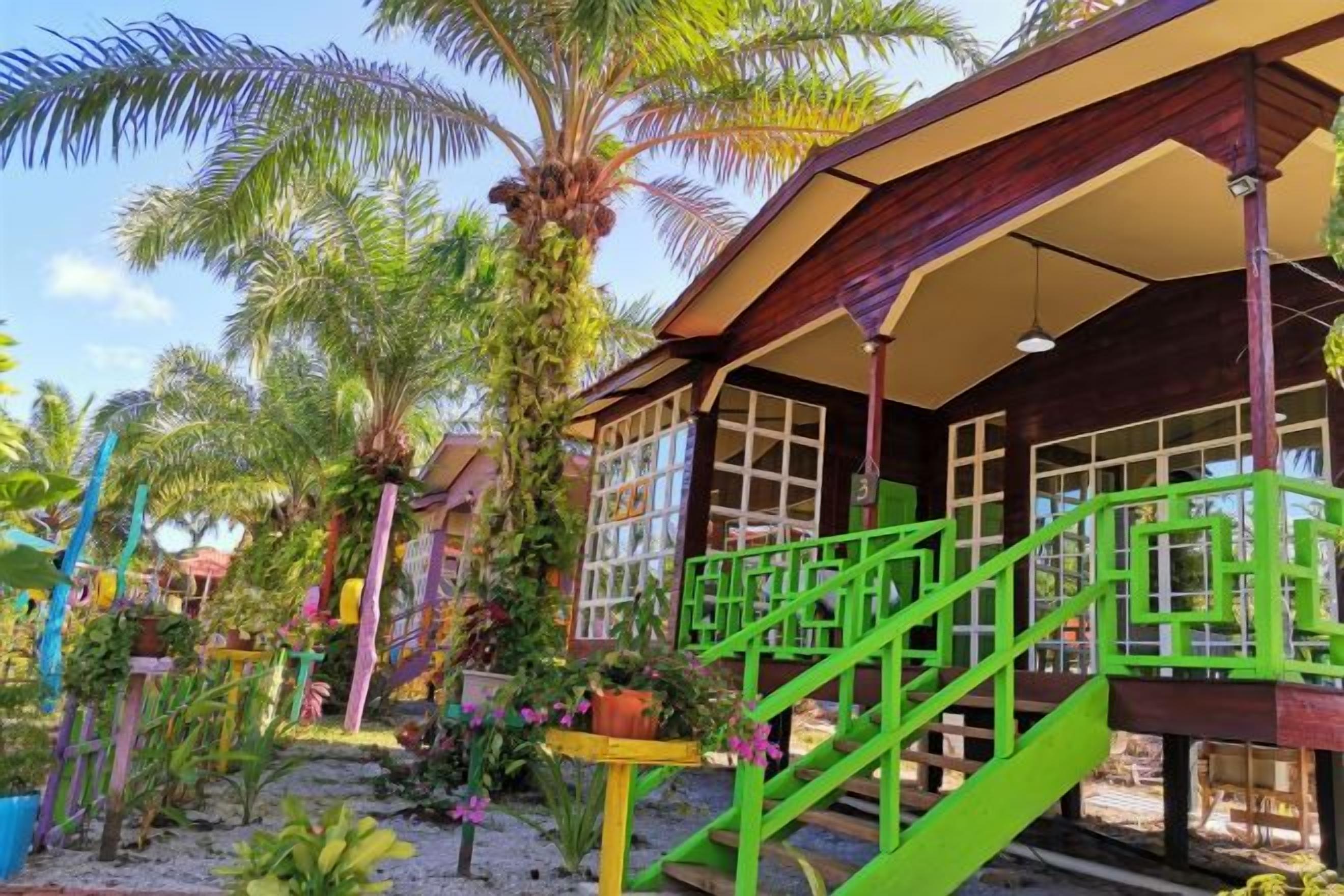 A building with a porch, green railings, and a staircase.