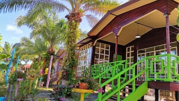 A building with a porch, green railings, and a staircase.