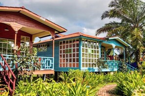 A two-story building with a covered porch and a balcony, surrounded by lush greenery. - Together Palm Resort (Semporna)