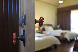 Une chambre d’hôtel avec un lit, une table de chevet et une porte dotée d’une serrure.